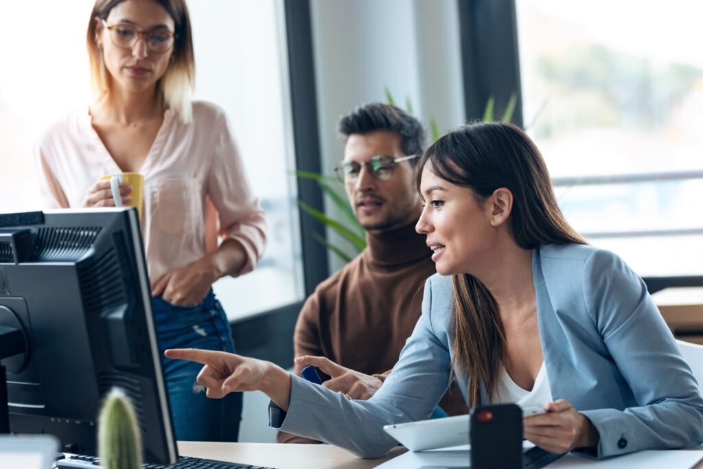 shot-successful-young-business-team-standing-around-computer-doing-video-call-coworking-space(1)